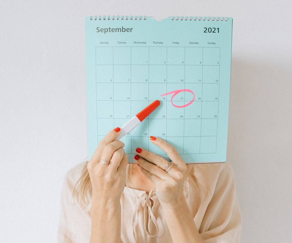 Woman holding a calendar with a a circled date